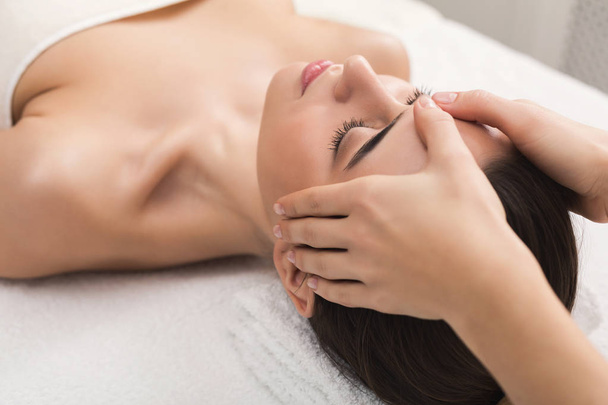 Mulher recebendo massagem facial profissional no salão de spa
 - Foto, Imagem