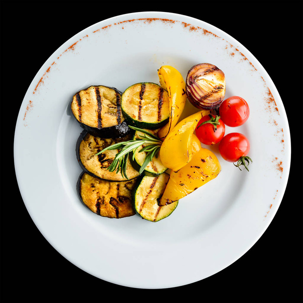Tasty baked eggplant with spices and tomato in a white plate on  - Фото, изображение