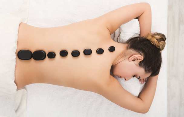 Woman getting hot stones massage at spa salon - Zdjęcie, obraz