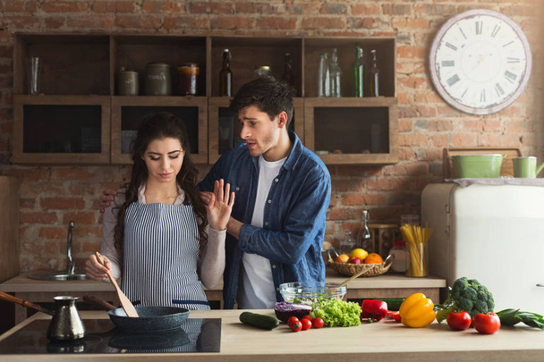 Пара готовит здоровый ужин и ссорится дома на кухне на чердаке. Мужчина и женщина спорят во время приготовления пищи, копируют пространство
 - Фото, изображение
