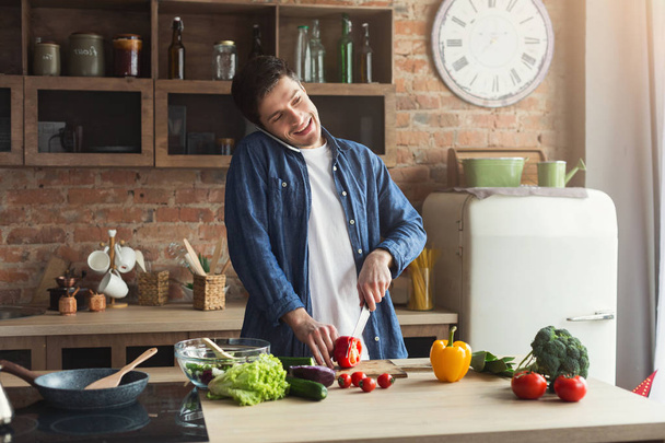 Homme heureux préparant des aliments sains dans la cuisine de la maison
 - Photo, image