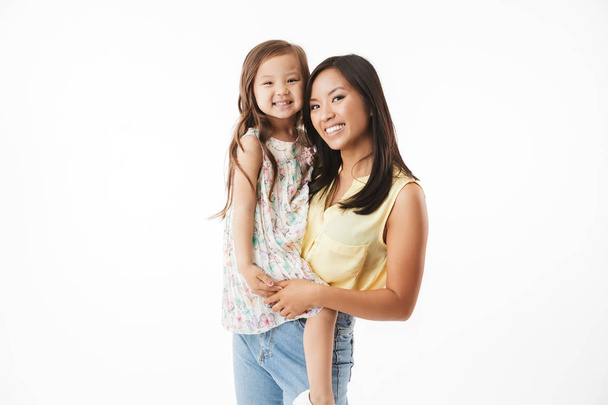 Image of happy young asian woman mother with her little girl child daughter isolated over white wall background. - Фото, зображення