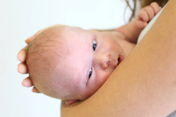 Portret van een pasgeboren kind in de handen van zijn mothet - Foto, afbeelding