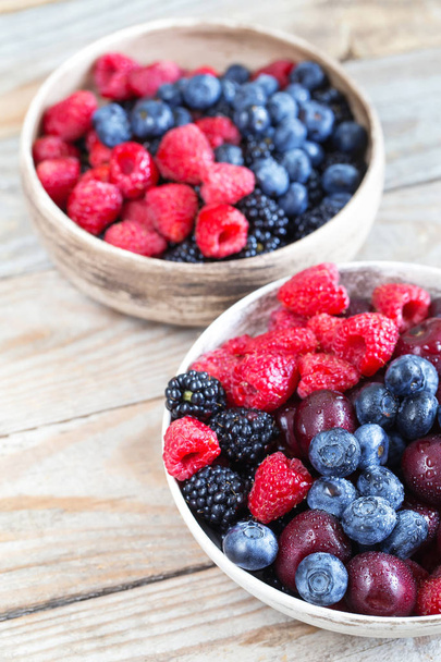 Various fresh summer berries in clay bowls. - Zdjęcie, obraz