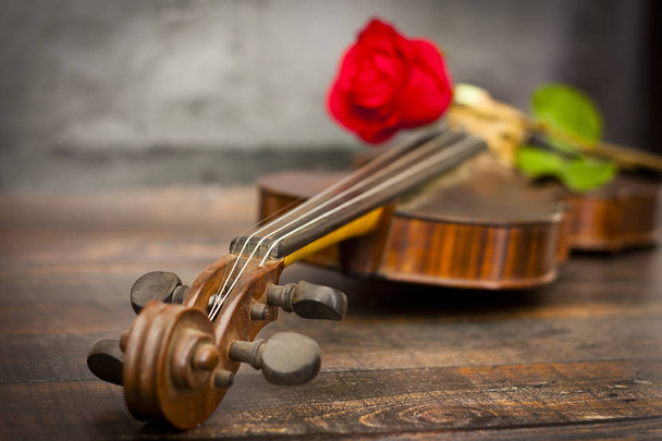 Hegedű és a vörös rózsa a fából készült asztal - Fotó, kép