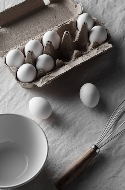 White eggs in an egg carton. White linen tablecloth background. - Fotoğraf, Görsel