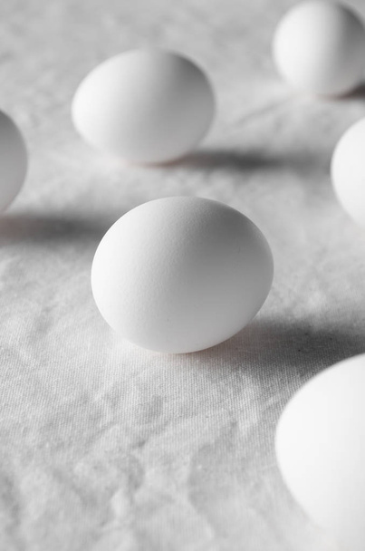 Close-up of white eggs on a white linen tablecloth background. - Valokuva, kuva