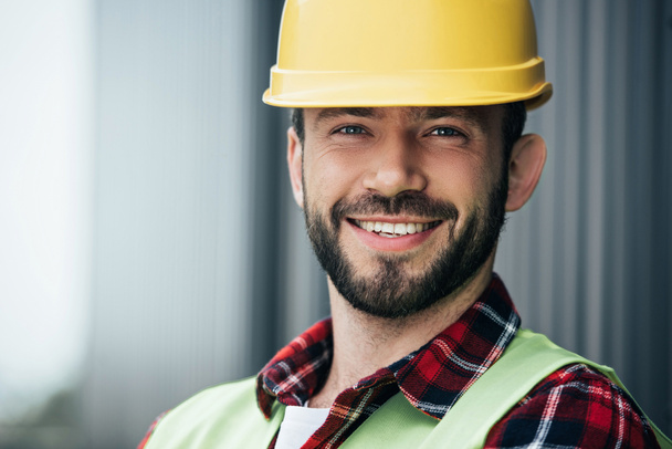retrato del trabajador sonriente masculino en casco amarillo
  - Foto, Imagen