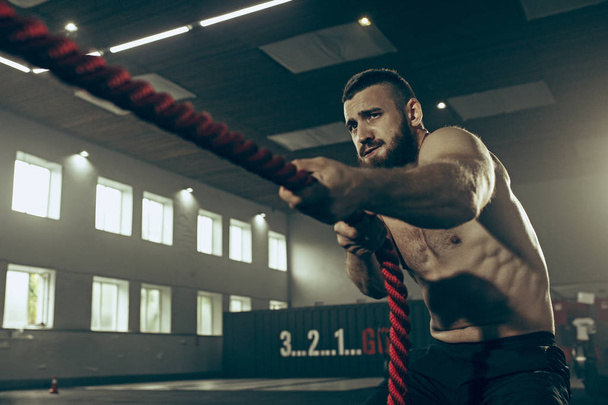 Men with battle rope battle ropes exercise in the fitness gym. - Foto, Imagem