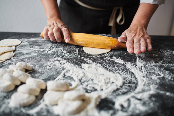 Woman rolling the dough by hands - Foto, imagen