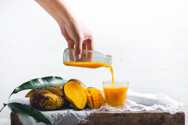 nature mango and mango juice On a wooden table and a white cloth - 写真・画像