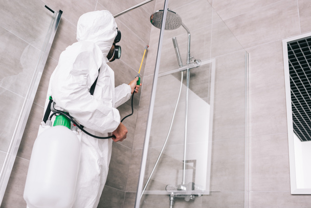 浴室で噴霧器で農薬を散布害虫制御労働者のローアングル ビュー - 写真・画像