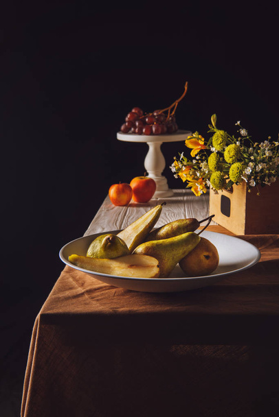 close-up shot of various fruits and field flowers on table on black - Foto, afbeelding