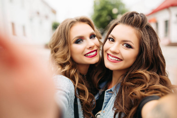Mooie tiener meisjes met kapsels en rode lippen glimlachend op camera. - Foto, afbeelding