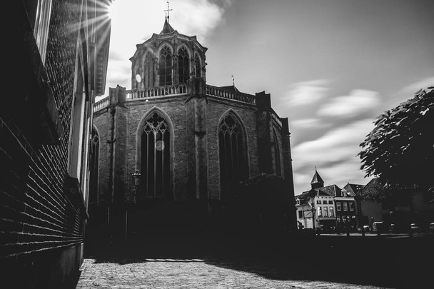 die "Bovenkerk" als riesige aufstrebende Kirche. typische gotische Architektur mit beeindruckenden Fenstern und Stildetails aus dem späten Mittelalter. Schwarz wot Foto mit Hintergrundbeleuchtung von der Sonne - Foto, Bild