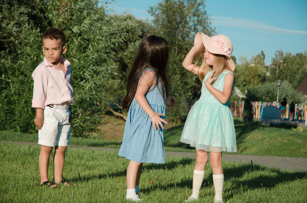 les petits enfants qui jouent sur la pelouse. deux filles et un garçon
 - Photo, image
