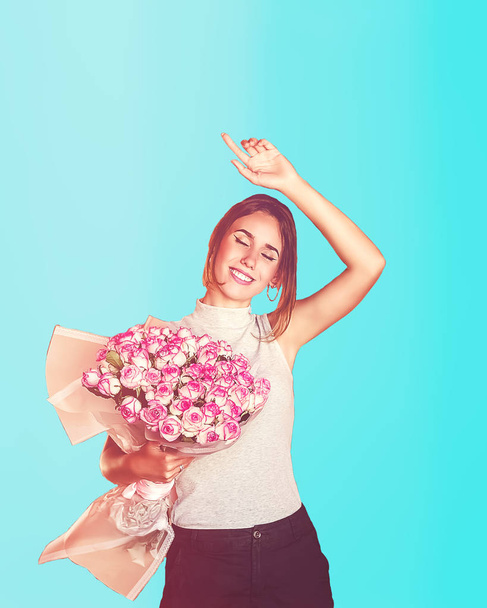 the happy girl. birthday. a large bouquet of flowers. blue background - Photo, Image