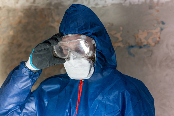 A man in blue protective suit, glasses and respirator - Photo, Image
