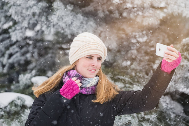 Happy woman taking selfie over winter background. - Foto, Bild