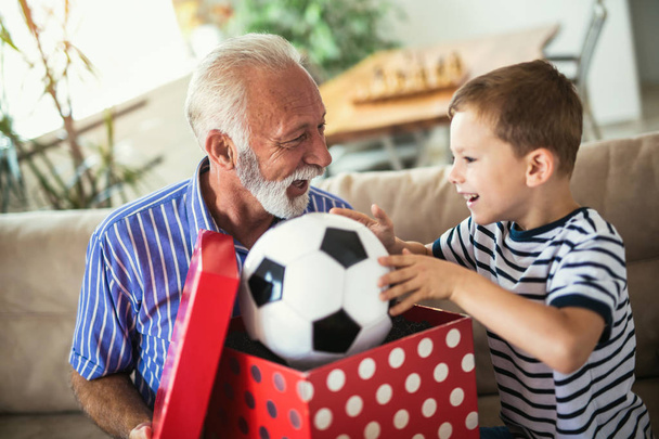 Senior grootvader presenteren geschenk aan gelukkig kleinzoon - Foto, afbeelding