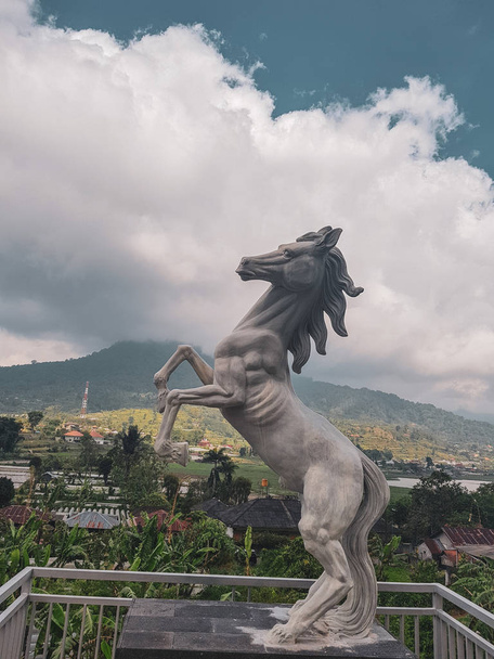 Pferdeskulptur über schönen Bergblick an bewölkten Sommertagen - Foto, Bild