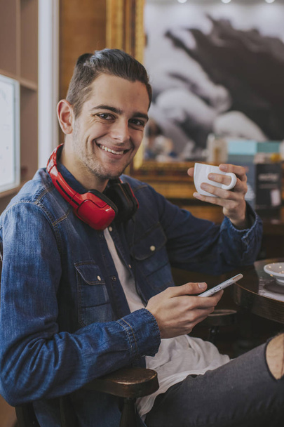 muotokuva nuorten kuulokkeet ja puhelin kahvilassa
 - Valokuva, kuva