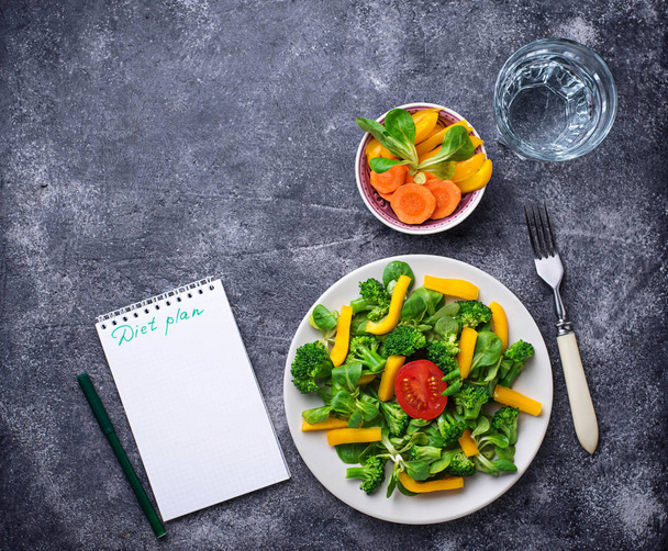 Healthy salad, clean water and measuring tape.  Weigh loss concept - 写真・画像