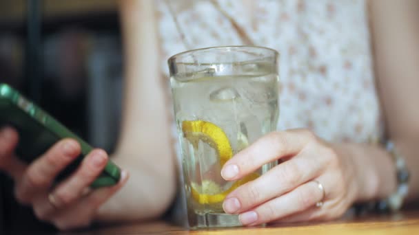 eine Frau trinkt in einem Restaurant einen Cocktail und telefoniert - Filmmaterial, Video