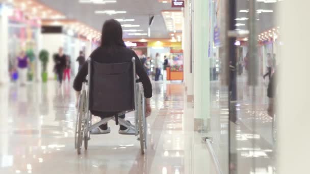 Mujer con discapacidad en silla de ruedas que va al centro comercial
 - Metraje, vídeo