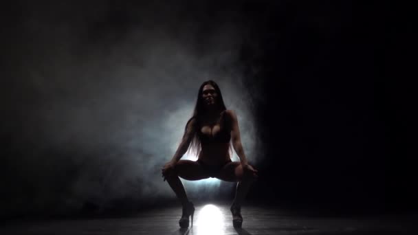 Tänzer führt sexuelle Bewegungen aus. schwarzer Rauchhintergrund. Zeitlupe - Filmmaterial, Video