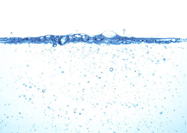 Κοντινό επιφάνεια εκτοξευμένο νερό με φυσαλίδες και σταγόνες που απομονώνονται σε λευκό φόντο, χαμηλή γωνία υποβρύχια προβολή - Φωτογραφία, εικόνα