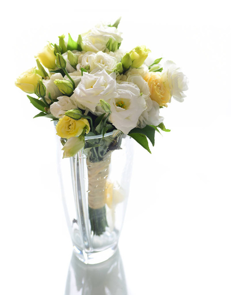 Kimppu valkoinen ja keltainen eustoma kukkia lasi maljakko eristetty valkoisella pohjalla
 - Valokuva, kuva