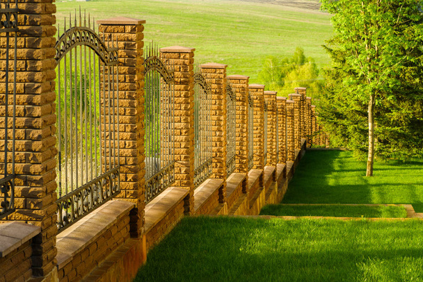 Taş sütunlar ile metalden yapılmış sahte çit - Fotoğraf, Görsel