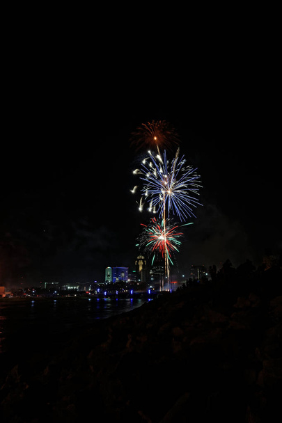 Fuochi d'artificio esplodono sullo skyline di Des Moines. Il Financial Center e gli edifici EMC sono illuminati per la festa del Giorno dell'Indipendenza
. - Foto, immagini