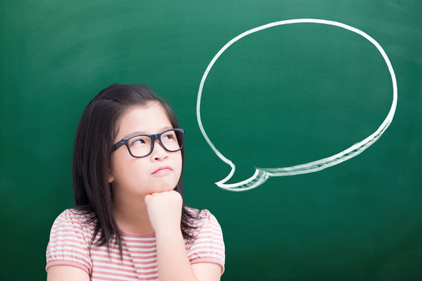 unhappy girl thinking  something with speech bubble on green chalkboard - Photo, Image