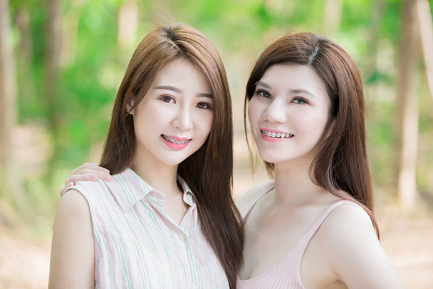 kaksi kauneutta naiset yllään hammasraudat hymyilevä
  - Valokuva, kuva