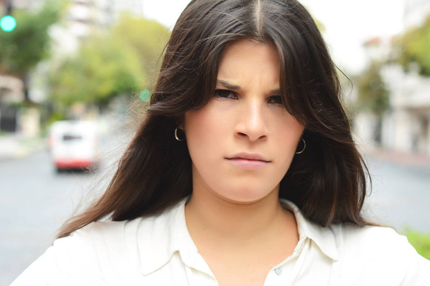 Angry young woman with sceptical and distrustful look. Human facial expression. - 写真・画像