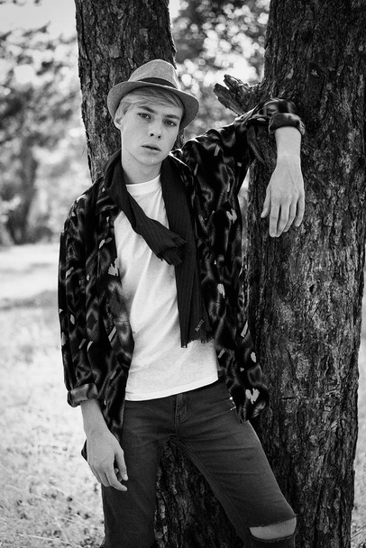 black and white photo of stylish young man posing outdoors  - Fotoğraf, Görsel