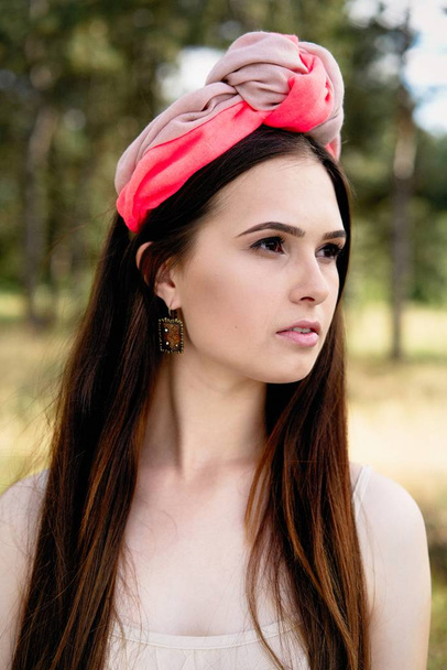 attractive young woman in beautiful headdress posing outdoors  - Foto, Imagem