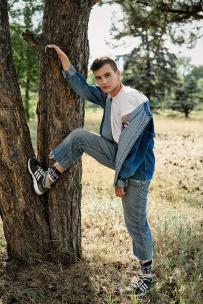 Handsome young guy in casual denim clothes posing outdoors  - Фото, изображение