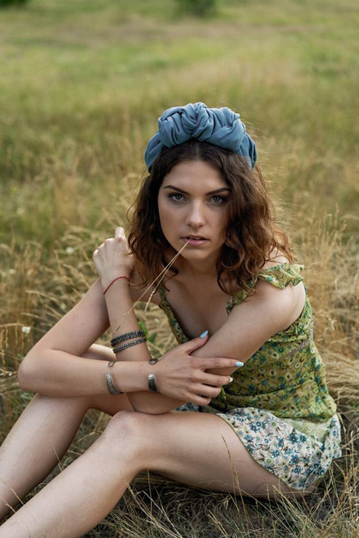 attractive young woman in beautiful headdress posing outdoors  - Foto, Bild