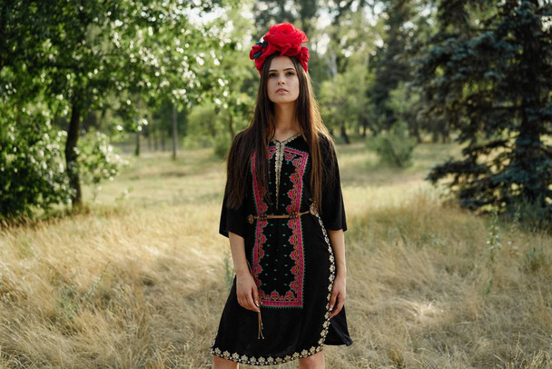attractive young woman in beautiful headdress posing outdoors  - Foto, imagen