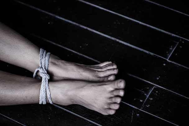 Vértes nő lába volt kötve, egy kötéllel. Erőszak, rémült, emberi jogok napján koncepció. - Fotó, kép