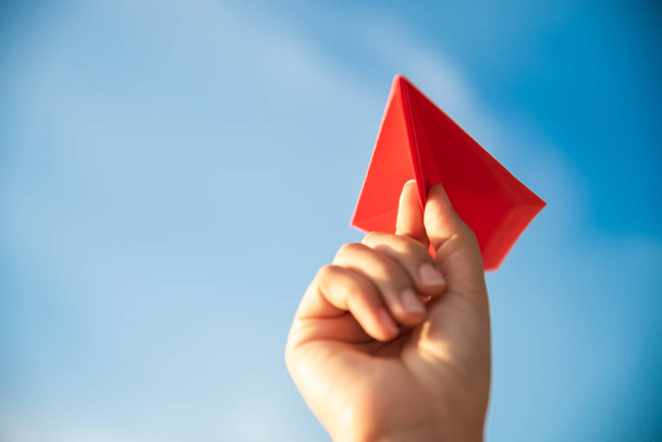 Soft focus sur Femme Main tenant fusée en papier rouge avec fond bleu ciel. concept de liberté
. - Photo, image