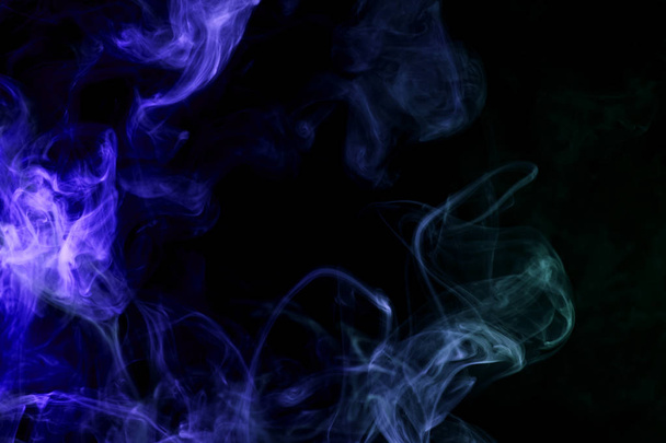 Humo azul denso multicolor sobre un fondo negro aislado. Antecedentes de humo vap
 - Foto, imagen