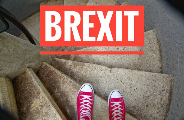 Zapatillas rojas en escalera de caracol al ir cuesta abajo con inscripción Brexit que simboliza la retirada de Gran Bretaña de la UE
 - Foto, Imagen