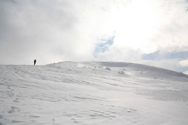 Ustrzyki Gorne, Πολωνία - 24 Φεβρουαρίου 2018: Ο άνθρωπος εισέρχεται στα βουνά το χειμώνα. Ορειβατικό μονοπάτι για να Tarnica το χειμώνα. Bieszczady εθνικό πάρκο το χειμώνα. Χιονισμένα δέντρα και βουνά. - Φωτογραφία, εικόνα