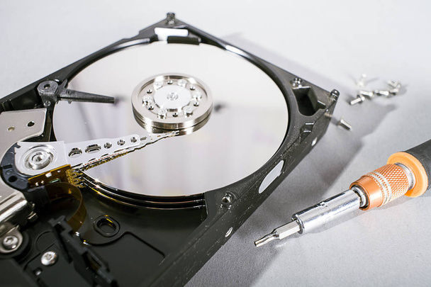 Hard disk drive platter. Open hdd hard disk. Data recovery from damaged media. Disk head above the plates - Photo, Image