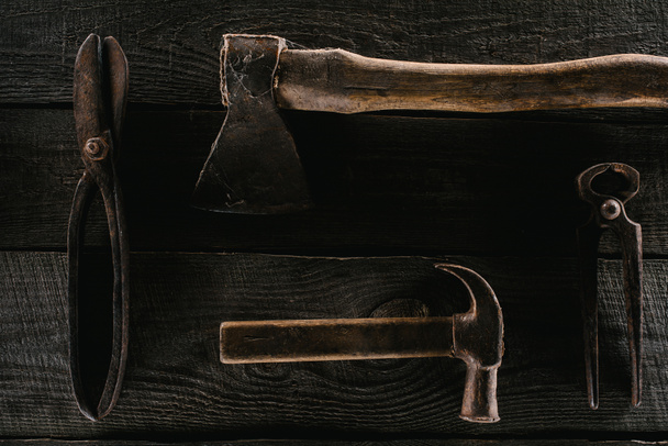  flat lay with arranged vintage axe, pliers, scissors and hammer on wooden surface - 写真・画像
