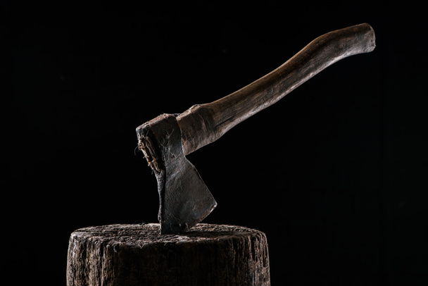  close up view of vintage axe on wooden stump isolated on black - Fotó, kép